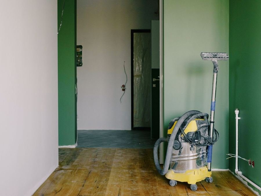 Industrial vacuum cleaner standing in a freshly renovated, unfurnished apartment